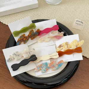 Macro detail of various colorful acetate wave hair clips on a premium display card