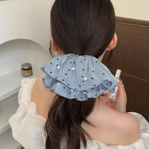 Elegant light blue pearl scrunchie with black polka dots shown on a ponytail