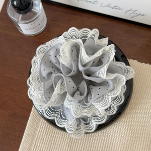 Detailed view of grey polka dot lace scrunchie with intricate white scalloped edges