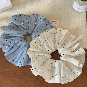 Detail of blue and cream polka dot scrunchies with elegant pearls and pleats