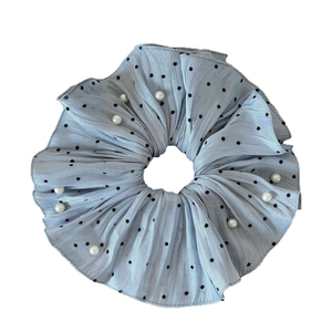 Light blue pearl scrunchie with classic black polka dots and pleated fabric texture