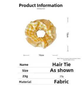Detail showing 16cm yellow plaid fabric scrunchie with embroidered cherry accents