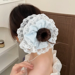 Chouchou bleu style ballet avec dentelle sur chignon dans un décor intérieur doux