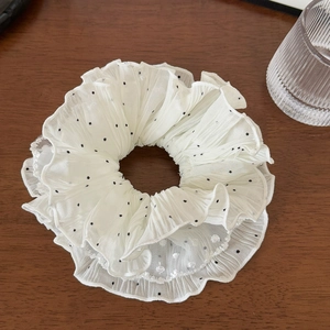 Macro detail of large layered white mesh hair scrunchie with classic black polka dots