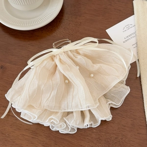 Close-up of beige layered lace hair claw clip with faux pearls and ribbon bow detail