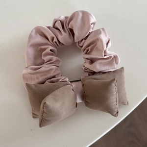 Roze kant haarelastiekje met een donkerbruine strik voor zoete kapsels