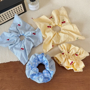 Sweet plaid scrunchies with cherry embroidery and scarf ties on wooden desk