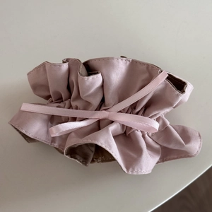 Roze satijnen haarelastiekje met geplooide kant en een sierlijke strik van lint