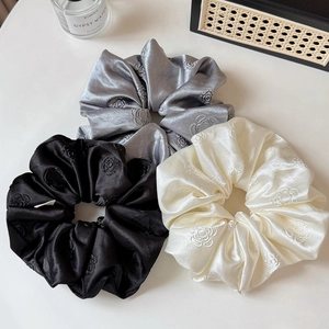 Three-piece set of elegant camellia satin scrunchies in black, silver gray, and cream white