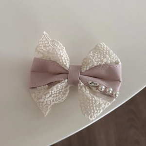 Haarelastiek met roze en beige kant strik, zilveren hanger en elegante parelaccenten
