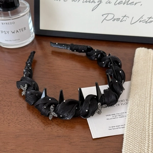 Detail of black twisted fabric headband featuring silver rhinestone butterflies and rivets