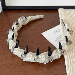 Detail view of gold polka dot mesh headband with crystals and anti-slip comb teeth