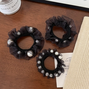 Elegant black mesh hair scrunchies with faux pearls set on a vintage wooden surface
