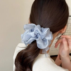 Light blue translucent organza scrunchie hair tie styled on a ponytail for women
