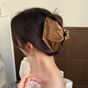 Elegant large bronze satin bow hair claw clip for bun hairstyles on professional model