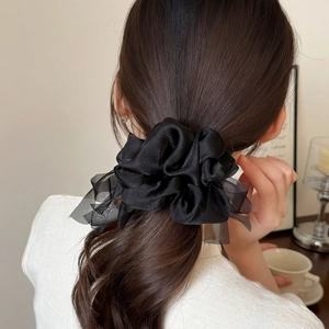 Detailed back view of a large black sheer organza bow scrunchie tied in a ponytail
