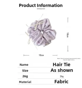 Vue détaillée du chouchou en tissu lavande à pois avec 18cm de diamètre et ruban