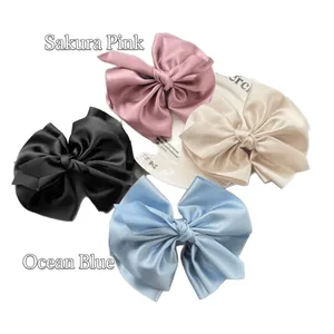 Elegante Haarklammern mit Satin-Schleifen in Rosa, Creme, Schwarz und Blau auf Tablett