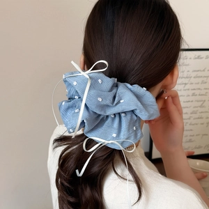 Chouchou bleu à pois avec un long ruban blanc pour une coiffure élégante et douce