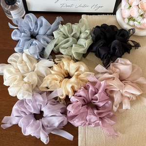 Detail of colorful organza scrunchies in lavender and pastel tones on an elegant background