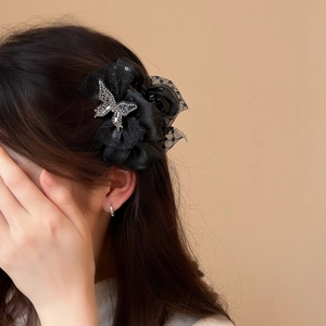 Detail of black satin and lace butterfly hair claw clip with silver crystal accents