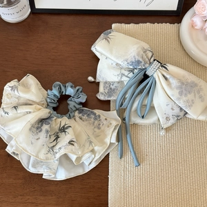 Detail view of ink-wash floral print hair scrunchie and bow clip with delicate pearls