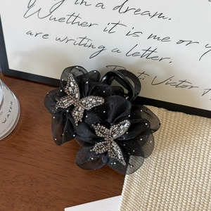 Detail of black organza hair claw clip with double rhinestone butterflies and star mesh