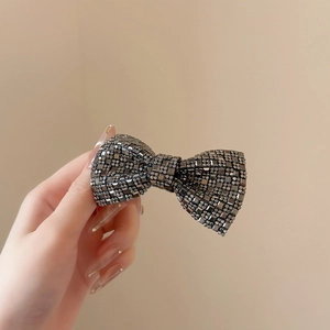 Nahaufnahme der funkelnden grauen Strass-Schleife Haarspange für Damen am Haar