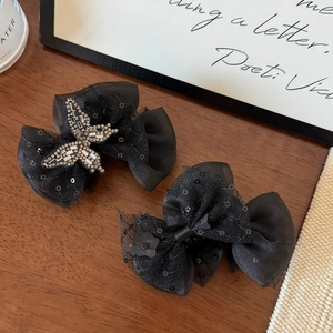Detailed view of black mesh butterfly hair claws featuring sequins and rhinestone butterfly charm