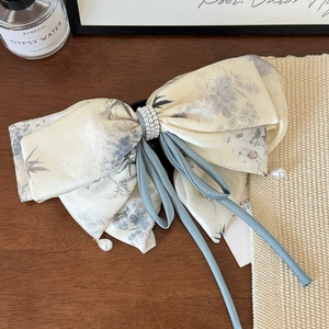 Detail of floral satin bow hair claw with blue ribbons and drop pearl pendants