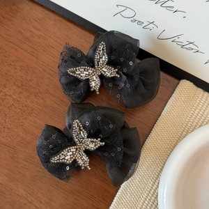 Close-up of elegant black lace butterfly hair clips with shimmering rhinestones and sequins