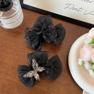 Detail showing elegant black mesh butterfly hair claws with rhinestones and sequins
