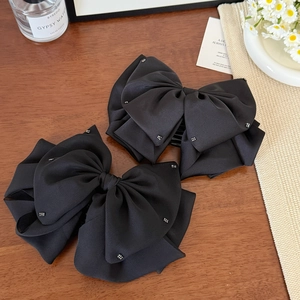 Elegant set of two large black satin bow hair clips with shimmering rhinestone accents