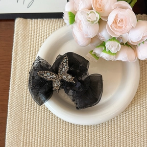 Detail of black lace butterfly hair claw clip with shimmering rhinestones and mesh fabric