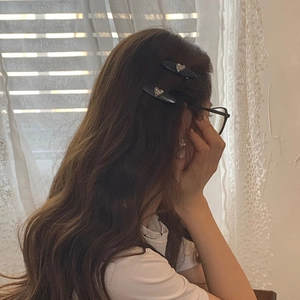 Barrettes à cheveux élégantes avec cœurs en strass bleu marine portées sur le côté