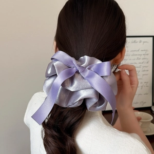 Chouchou élégant en satin lavande avec long nœud sur modèle, accessoire pour cheveux