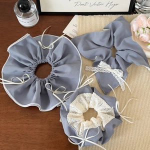 3-piece blue plaid scrunchies set with lace details and a bow hair tie on a wooden desk