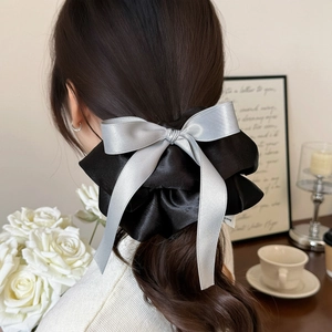 Chouchou élégant en satin avec nœud noir et gris argenté porté sur les cheveux
