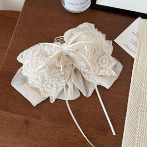 Detail of elegant lace bow hair clip with embroidery and white pearl accents