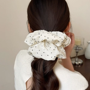 Polka dot oversized hair scrunchie in cream white fabric worn by model on ponytail