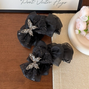Detail of elegant black butterfly hair claw with sequins and sparkling rhinestones