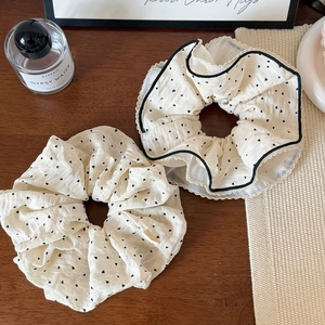Polka dot scrunchies set in cream chiffon with heart patterns on a wooden surface