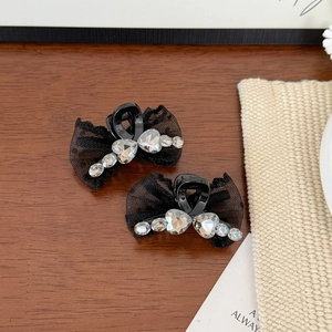 Barrettes à cheveux en dentelle noire avec strass en forme de cœur sur un bureau