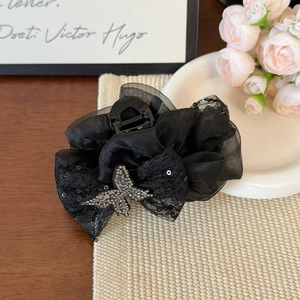 Detailed view of elegant black organza hair claw clip with butterfly rhinestone embellishment