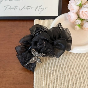 Close-up of black mesh butterfly hair claw with lace sequins and silver rhinestone detail