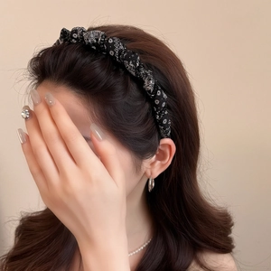 Elegant black paisley print twisted headband for women showing a high-volume hair accessory look