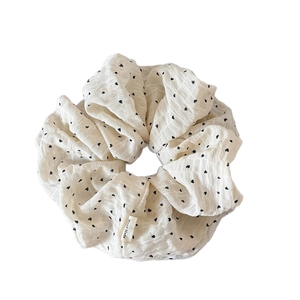 Elegant white polka dot scrunchie with black heart pattern and handmade woven label