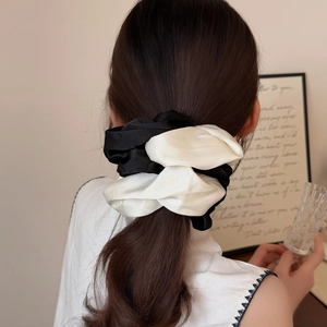 Elegant large black and white contrast satin scrunchie worn on a high ponytail