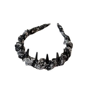 Black paisley headband with punk style spikes and crystal bead accents on white background