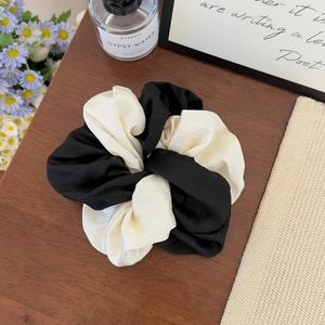 Elegant black and white contrast satin scrunchie for ponytail styling in home setting